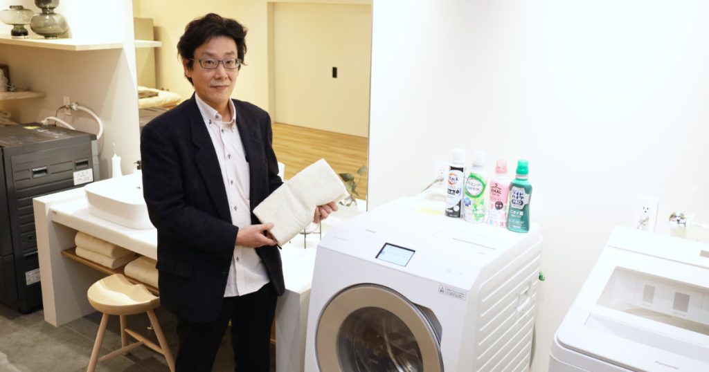 ドラム式洗濯乾燥機の横に立つ、パナソニック広報の秦慶治さん